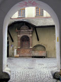 Der Blick aus der Torhalle heraus, zeigt im Innenhof einen rotmarmornen Brunnen ...