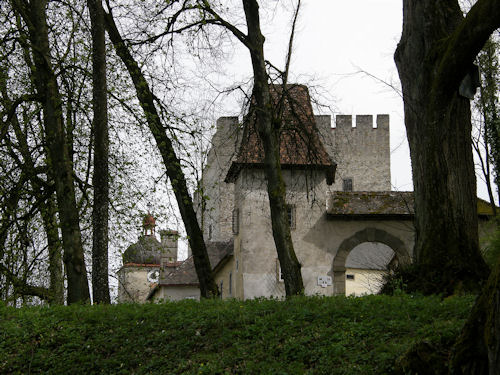 Durch einen romantischen Park mit alten Bäumen kommend, öffnet sich der westseitige Zugang zur Burg.